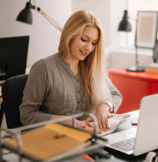 Woman opening folder about PEO services near laptop