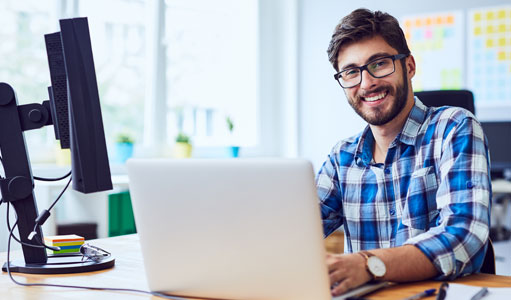 PEO smiling behind laptop