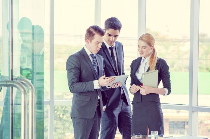 Employees discussing the contents of a tablet