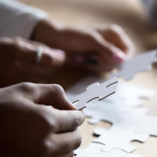 Hands putting together a puzzle piece