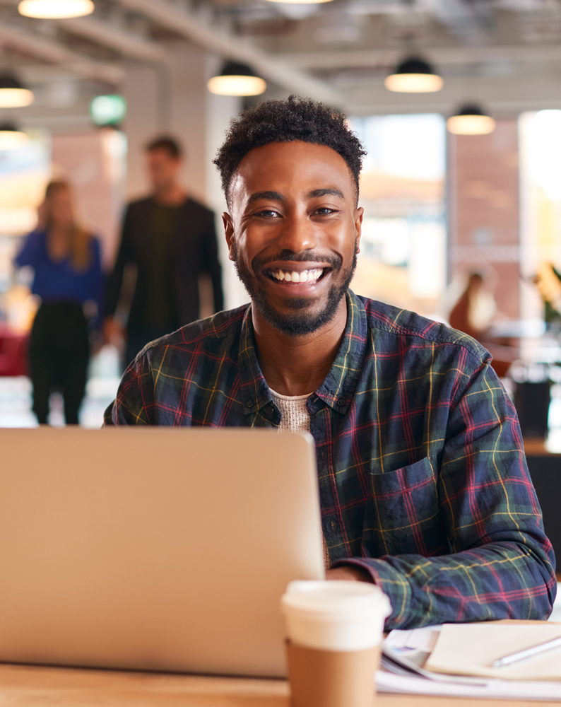 Smiling employee working in front of a laptop