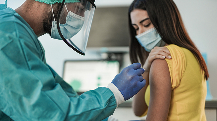A doctor administrating a COVID-19 vaccine to a patient