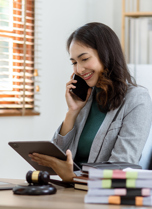 Services - Compliance Services - Compliance - Female on the phone looking at a tablet