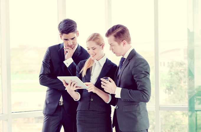 Employees discussing the contents of a tablet